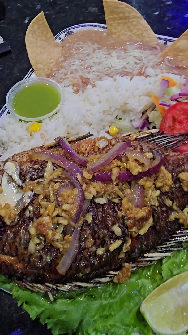 Mexican seafood meal with drinks nearby.