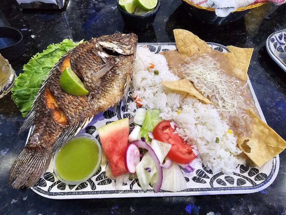 Printed menu featuring aguachiles and fajitas.
